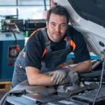 Zufriedener Kfz-Mechaniker oder Techniker am Auto, der seine Prodiags-Trainingsgeschichte erzählt